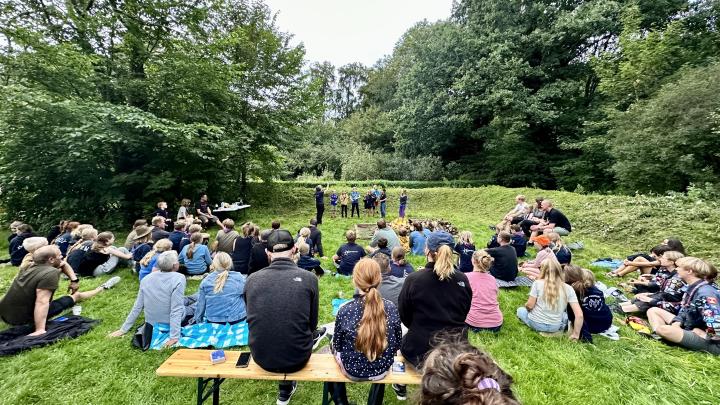 Billede fra vores oprykning 2023. Billedet viser mange mennesker på et grønt område.