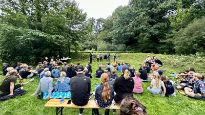 Billede fra vores oprykning 2023. Billedet viser mange mennesker på et grønt område.